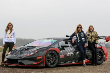 girls stood in front of a lamborghini gt3 car