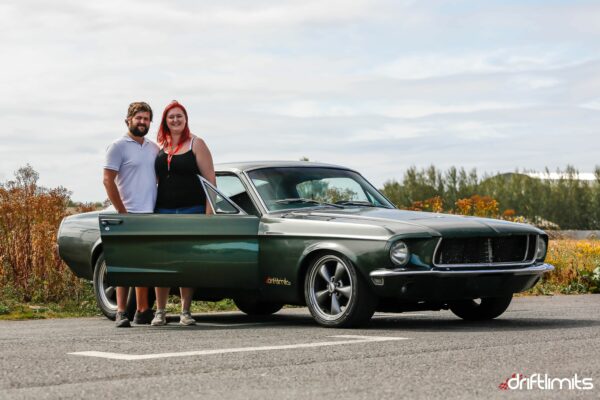 couple stood next to a mustang